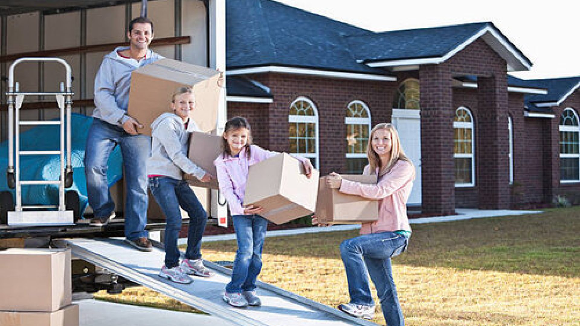 Moving house.  Family loading or unloading moving van.